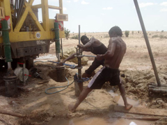 Technicians install a submersible pump in a borehole prior to test pumping.: PHOTOGRAPH © UNESCO/Nairobi Office
